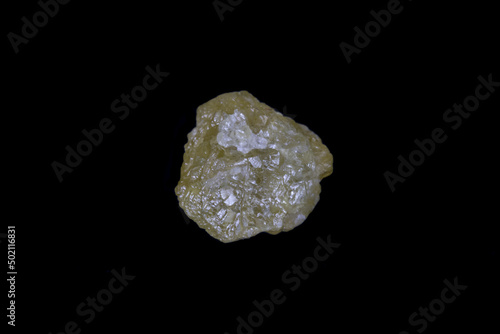 Raw, uncut yellow diamond. 5.7mm diameter, weight 1.9 carats. On Black background. 