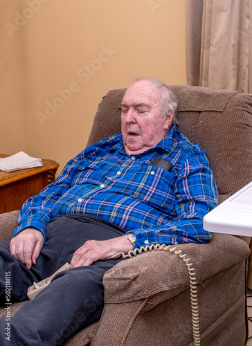 фотографія senior in a lift chair, sound asleep in his living room