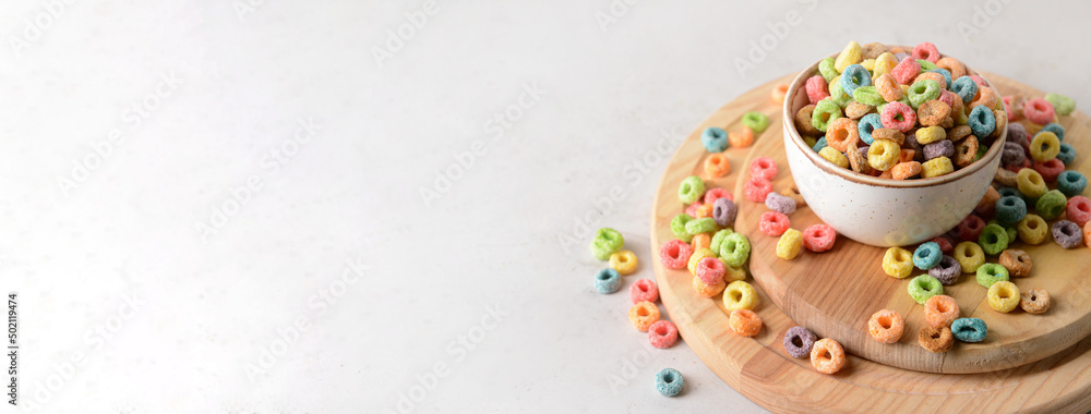 Bowl with crunchy corn rings on grey background with space for text