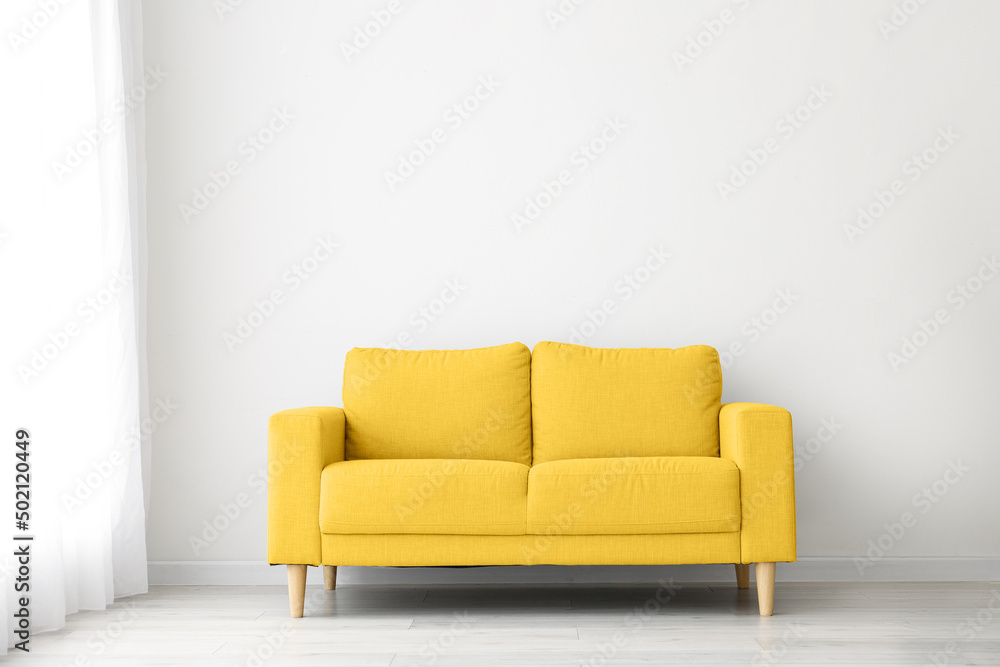 Comfortable yellow sofa near light wall Comfortable yellow sofa near light wall