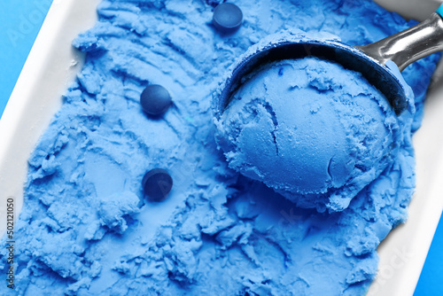 Scoop in bowl with tasty blue spirulina ice-cream and pills, closeup photo