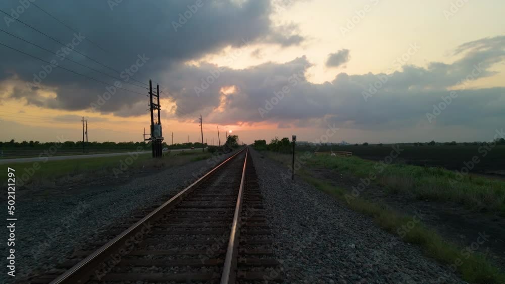 Drone Shot Following Low Over Empty Railroad Tracks Toward Setting Sun In Texas, U.S.A. Drone Shot Following Low Over Empty Railroad Tracks Toward Setting Sun In Texas, U.S.A.