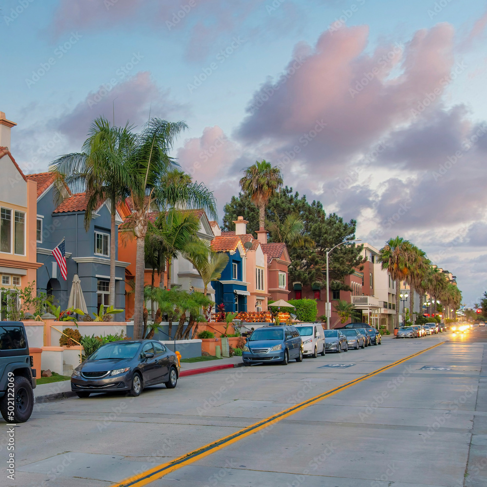 Square Puffy clouds at sunset Road in the middle of the residential buildings with parked vehi