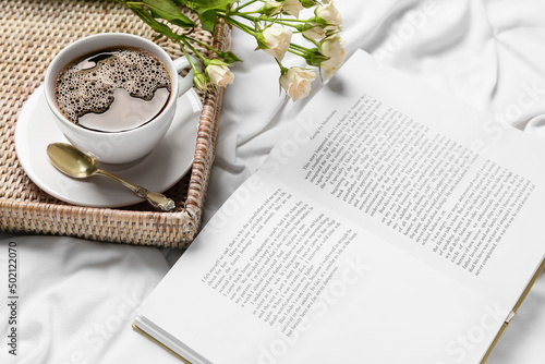 Opened book, tray with cup ...