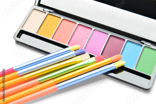 Colorful makeup brushes with eyeshadows on white background  closeup
