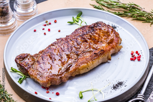 juicy Striploin Steak on grey plate on table