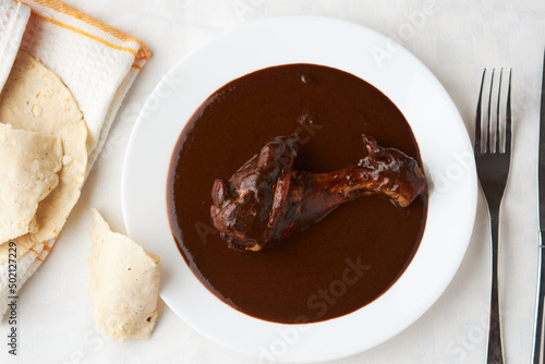 Chicken with mole, tortilla around ready to serve, Mexican tradition, placed on wood