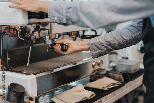 Close-up view on barista hands to making coffee with coffee machine. Coffee owner concept.