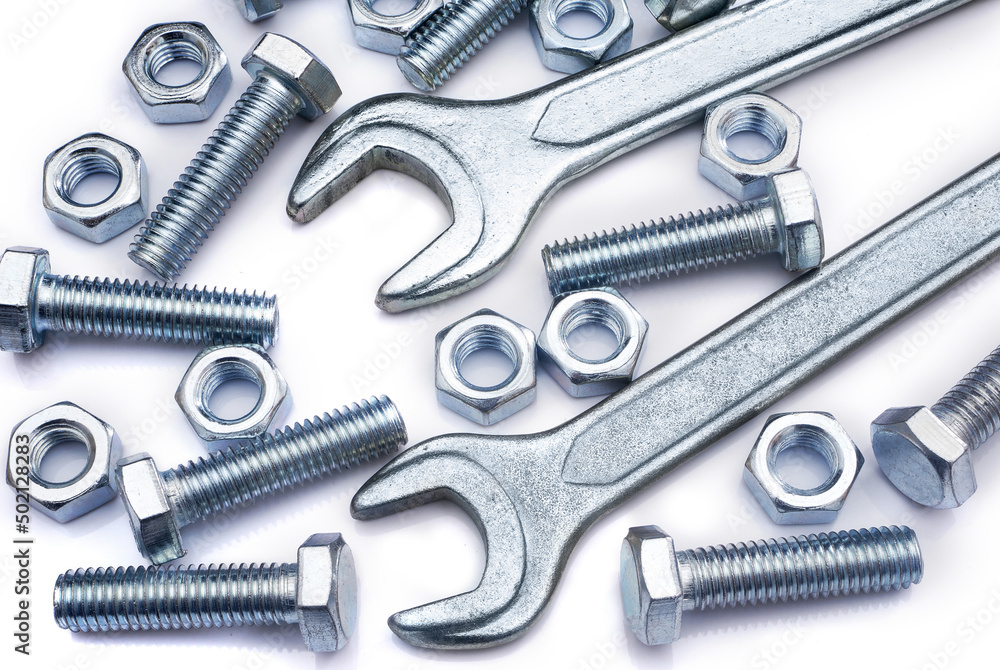 Screws, nuts and wrenches on white background. Industrial background. Top view on various fasteners and spanners. Screws, nuts and wrenches on white background. Industrial background. Top view on various fasteners and spanners.