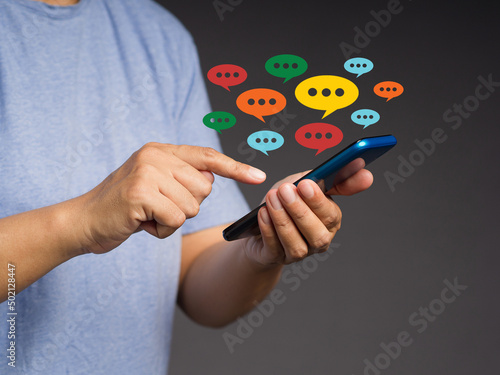 Close-up of hands using mobile phone with colorful chat icons on the application