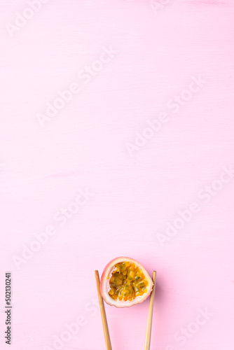 Fresh passion fruit with chopsticks on pink background  Tropical fruit in summer season