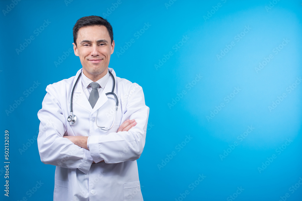 Positive physician crossing arms on blue background Positive physician crossing arms on blue background