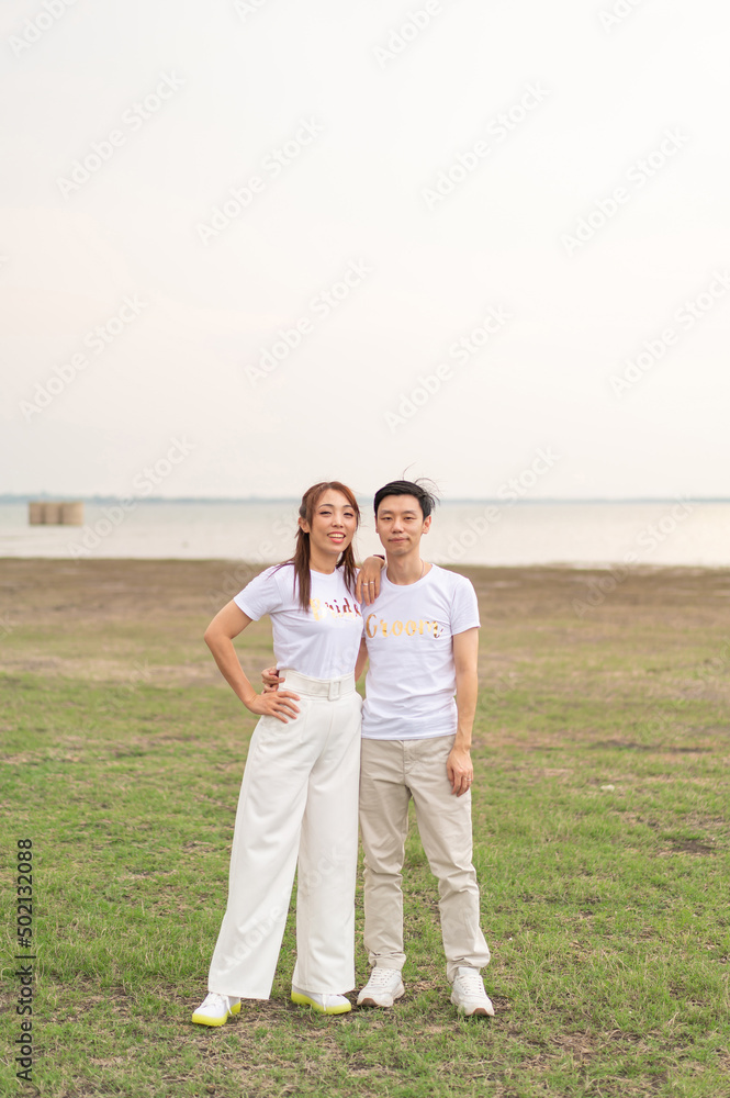 Happy young Asian couple in bride and groom t-shirt Happy young Asian couple in bride and groom t-shirt