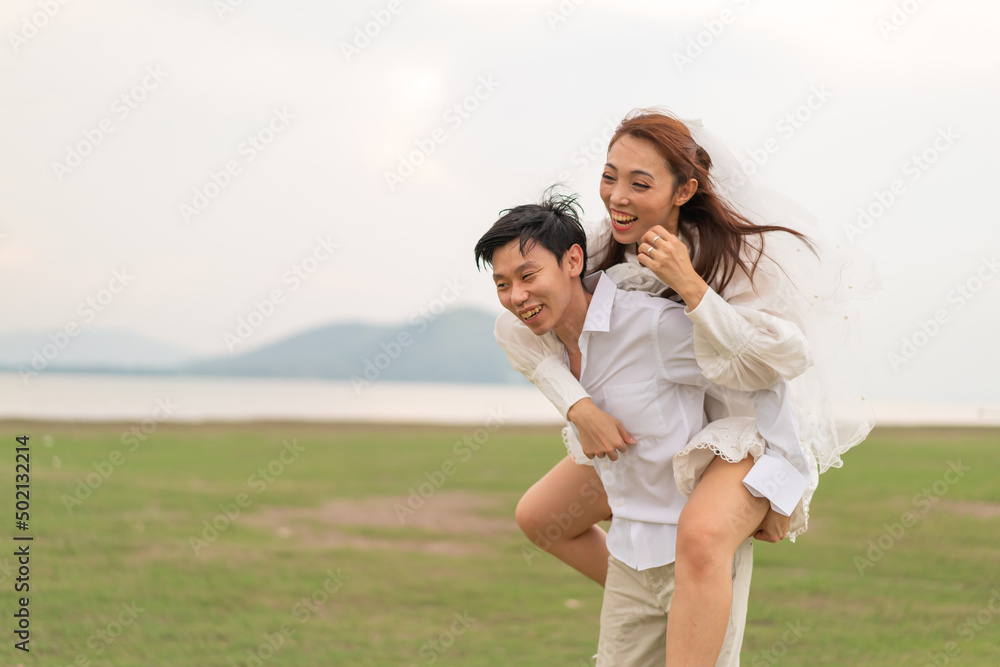 Happy young Asian couple in bride and groom clothing Happy young Asian couple in bride and groom clothing
