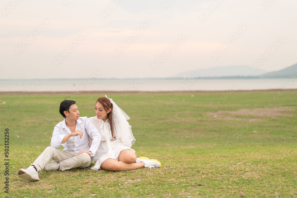 Happy young Asian couple in bride and groom clothing Happy young Asian couple in bride and groom clothing