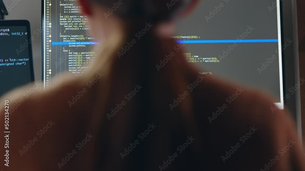 Young Asian woman, developer programmer, software engineer, IT support, wearing glasses working hard at night overtime on computer to check coding in bugging system. Back view