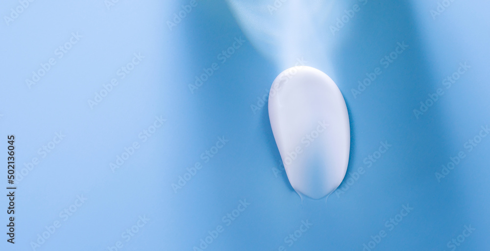smear of white cream on blue background with a beam of light
smear of white cream on blue background with a beam of light