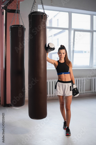 Photo shoot for a young athlete in the interior of a boxing gym with gloves and bags © romankosolapov
