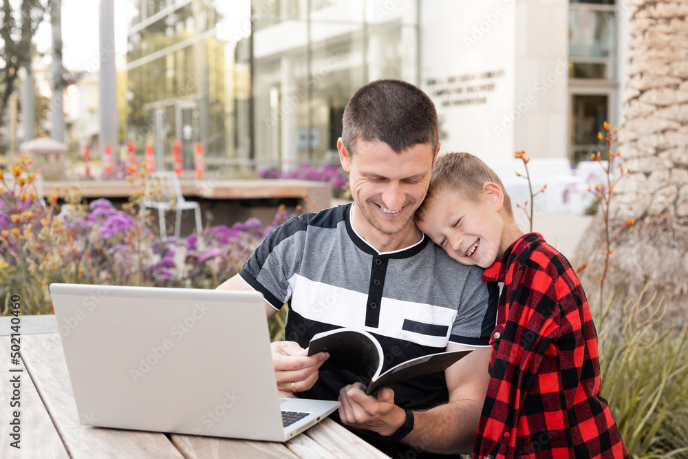 Young dad and son communicate and check homework.