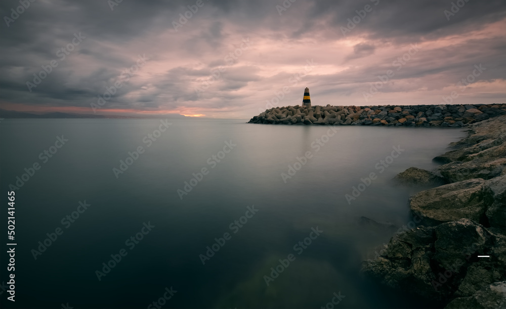 Cloudy sunrise scenery of Lighthouse at Banalmadena coast in Malaga, Spain 