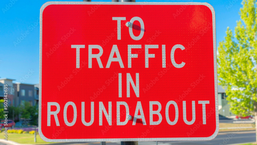 Panorama Red roadsign with white To traffic in roundabout at Daybreak in South Jordan, Utah