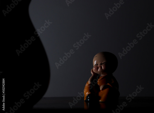 Idol of Cute Laughing Buddha with dark background and Abstract shape  photo