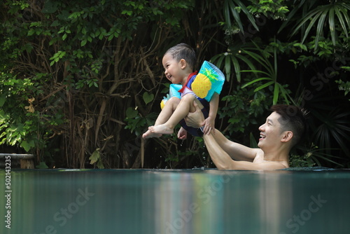 The Asian father and son feel happy in swimming pool The ifestyle playing and having fun outdoors at summer. photo