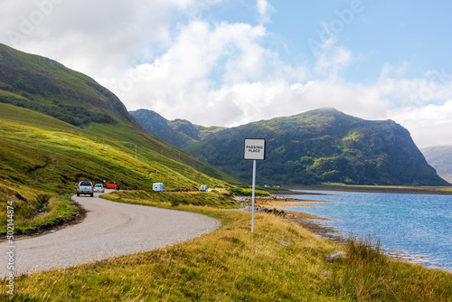 Slow-driving car on single wavy, serpentine road in North Coast 500, Scotland