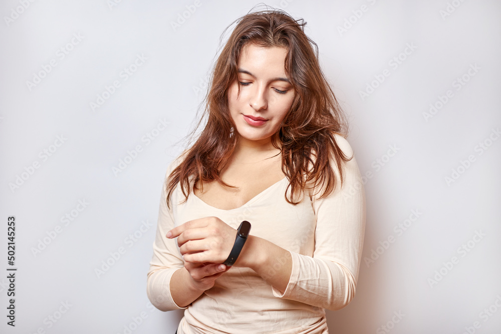 Naklejka premium Girl with a fitness bracelet on her arm. Modern gadgets and digital technologies in human life.