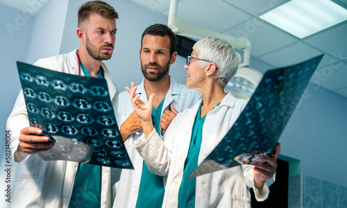 Group of radiology doctor looking at x-ray and discussing it. photo