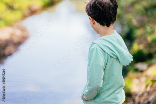 child with his back to the river