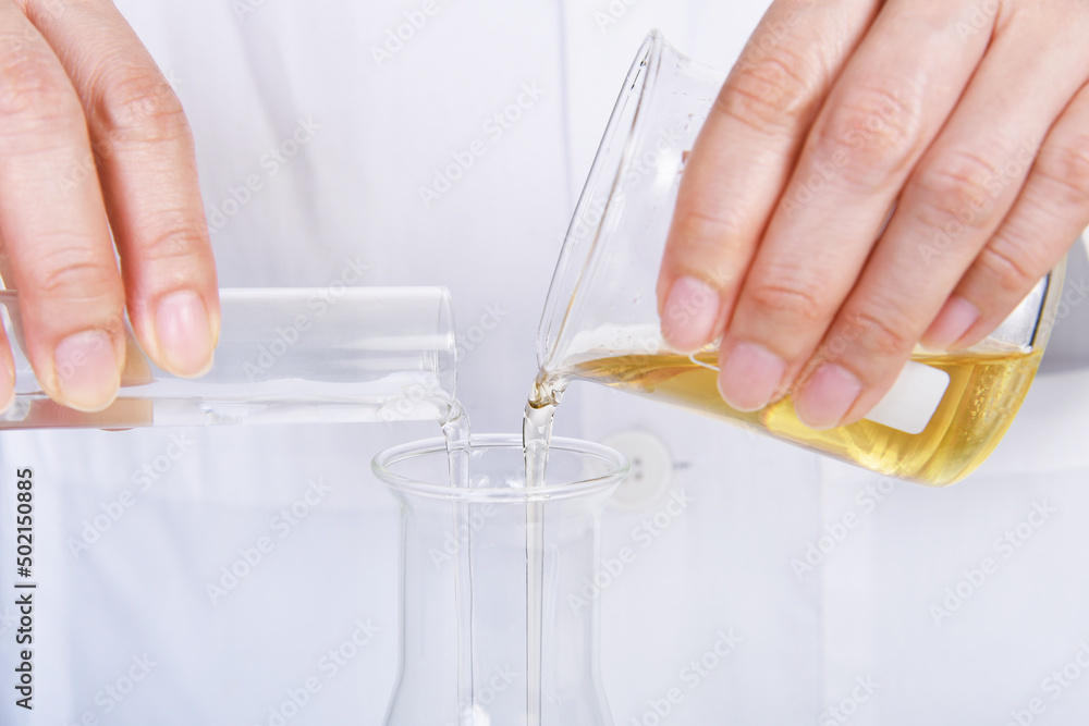 Chemical reagent pouring and mixing, Laboratory and science experiments, Oil formulating the chemical for medical research.