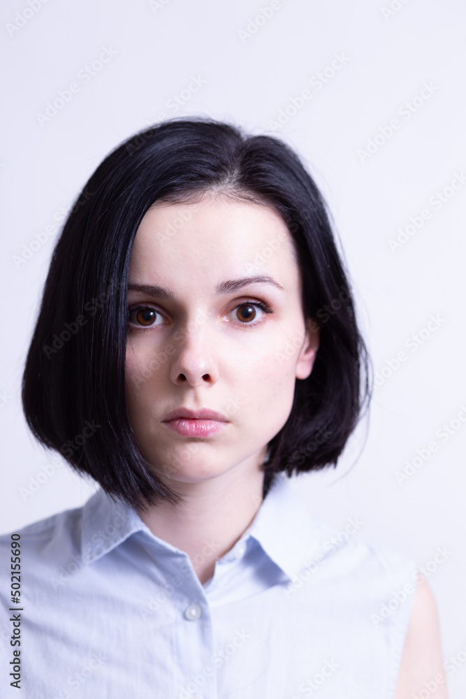 woman in a blue sleeveless office shirt, light background woman in a blue sleeveless office shirt, light background