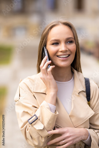 Happy business woman talking on phone in the street