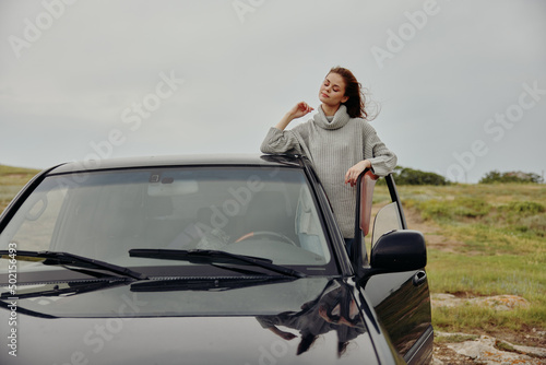 woman with red hair in a sweater near the car nature Lifestyle