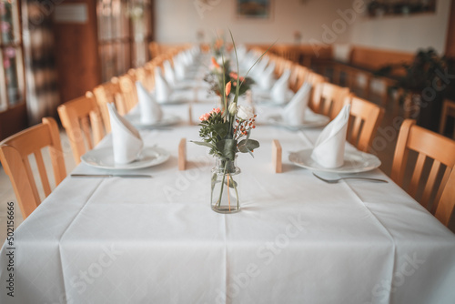 Gedeckter Festtisch einer Hochzeitsgesellschaft - gedeckt mit Tellern und Besteck