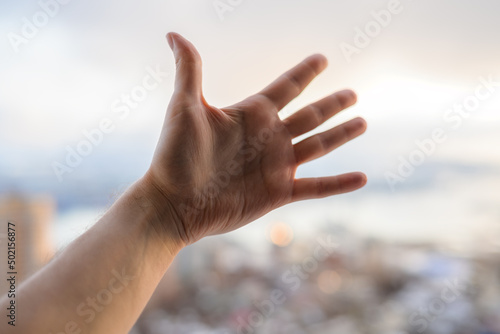 Hand of a man reaching to towards sky. © Vladimir Arndt
