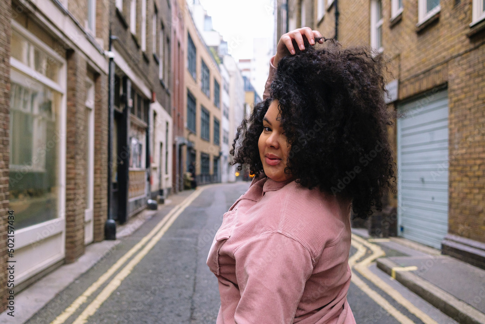 Young woman with hand in hair standing on road Young woman with hand in hair standing on road