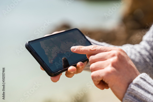 Hands of woman using map on smart phone photo