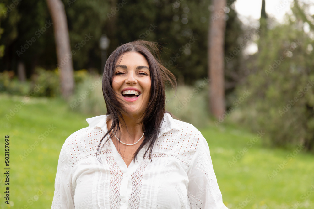 Cheerful woman with long hair enjoying at park Cheerful woman with long hair enjoying at park