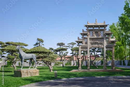 Fototapeta ancient archway building architecture with pine tree and meadow