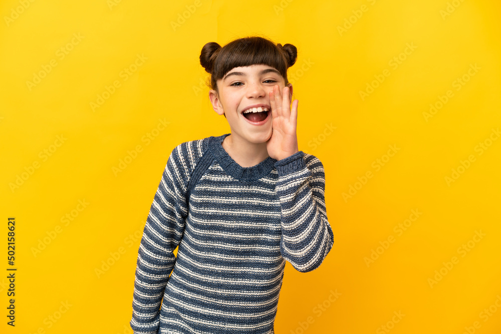 Fototapeta premium Little caucasian girl isolated on yellow background shouting with mouth wide open