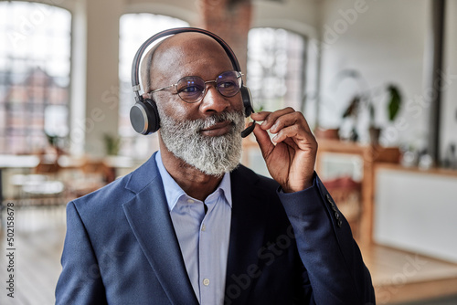 Businessman listening through headset at home