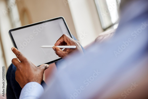 Businessman using digitized pen on tablet computer at home photo