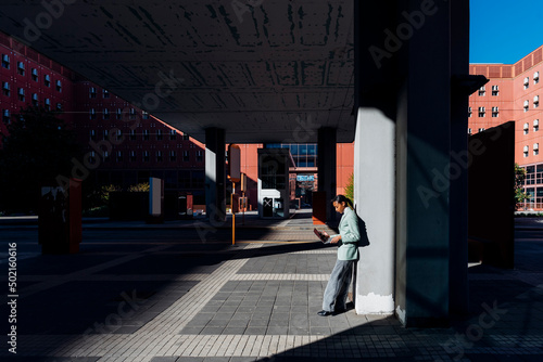 Working woman using laptop standing in downtown district photo