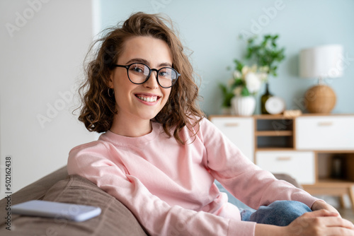 Happy woman wearing eyeglasses in living room at home photo
