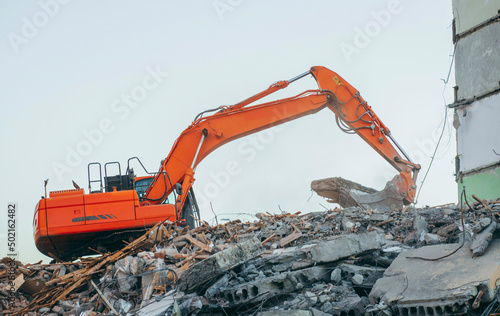 Process of demolition of building. Excavator breaking old house. 