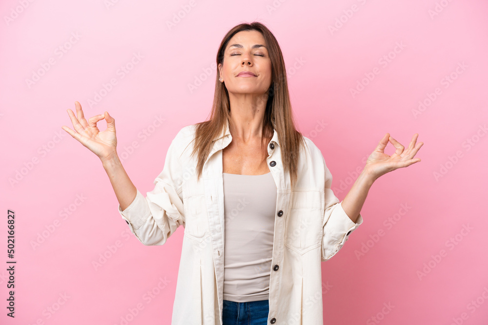 Middle age caucasian woman isolated on pink background in zen pose Middle age caucasian woman isolated on pink background in zen pose