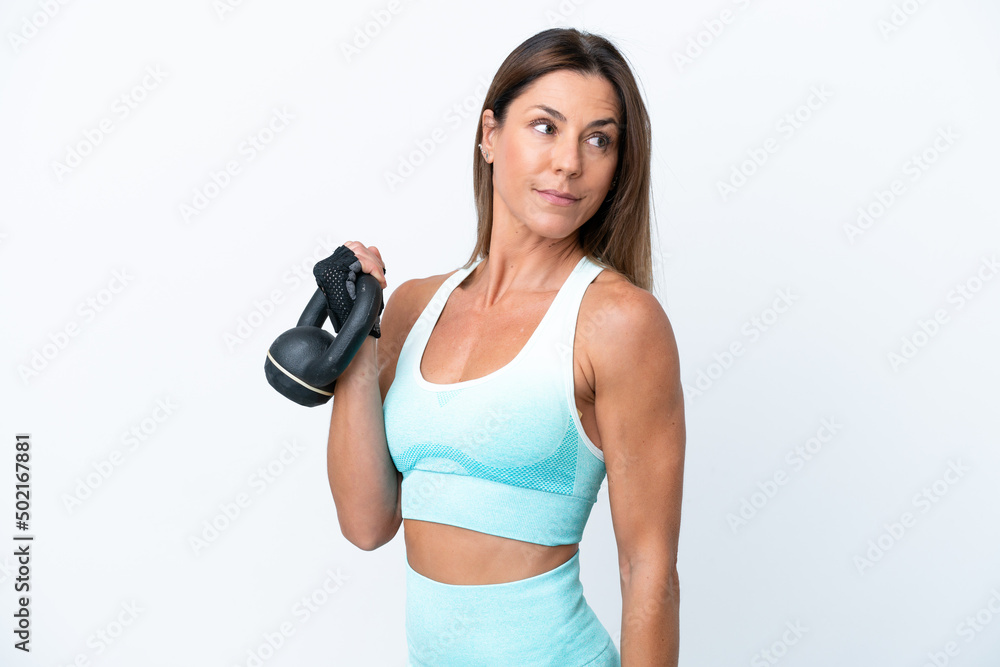 Middle age caucasian woman isolated on white background making weightlifting with kettlebell Middle age caucasian woman isolated on white background making weightlifting with kettlebell