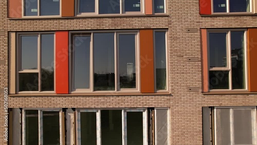 Closeup sideways and backwards aerial reveal of exterior facade of newly build apartment complex in Zutphen. Dutch engineering real estate social housing investment urban development photo